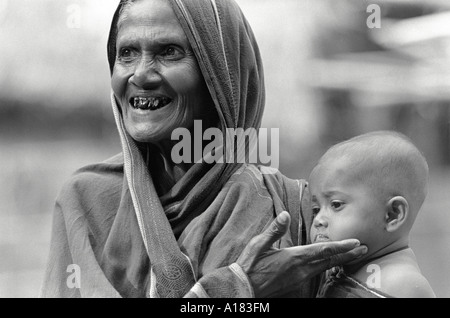 Ritratto B/N di una nonna che mostra con orgoglio il suo nipote bambino da un villaggio agricolo vicino Tangail, Bangladesh Foto Stock