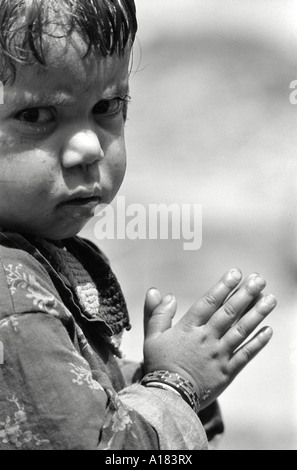 Primo piano ritratto di un bambino che dice le sue preghiere in un'assemblea scolastica rurale. Garhwal Himal, India Foto Stock