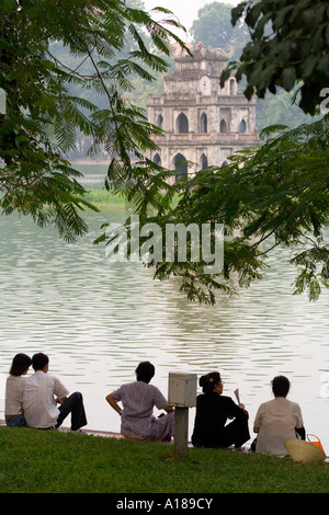 2007 donne siedono in su il corto nella parte anteriore del Thap Rua Tempio o torre di tartaruga Lago Hoan Kiem Hanoi Vietnam Foto Stock