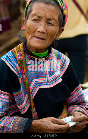 Anziani fiore donna Hmong Thumbs attraverso denaro Bacha mercato vicino a Sapa Vietnam Foto Stock