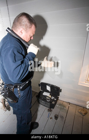 Scena del Crimine tecnico e Detective ispezionano il vetro rotto sulla scena di un furto con scasso Kansas City MO criminalità polizia Lab Foto Stock