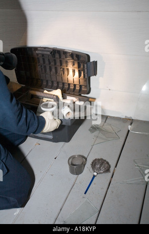 Scena del Crimine tecnico e Detective ispezionano il vetro rotto sulla scena di un furto con scasso Kansas City MO criminalità polizia Lab Foto Stock