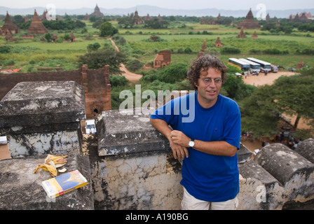 Comunità turistica maschio in posa per una fotografia con Bagan Paya templi come sfondo MYANMAR Birmania Foto Stock