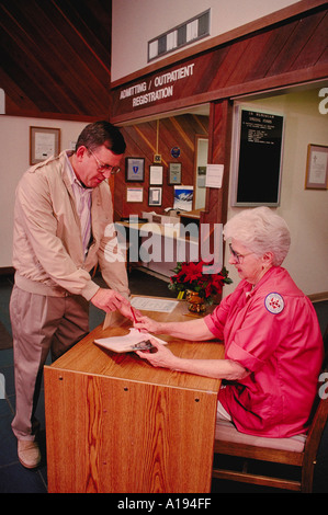 Ospedale volontario centralinista saluta CA del paziente Foto Stock