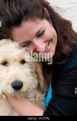 Donna età 39 godendo il suo animale domestico scarabocchio. Barboncino golden retriever incroci. St Paul Minnesota USA Foto Stock
