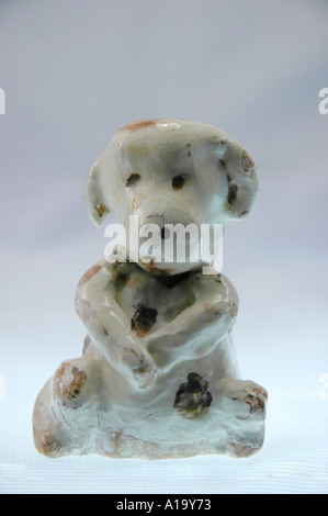 Vecchia ceramica artigianale cane figurina seduta con le sue zampe anteriori incrociate Foto Stock