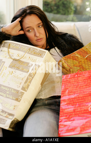 Donna che guarda esaurito circondato da sacchetti di shopping Foto Stock