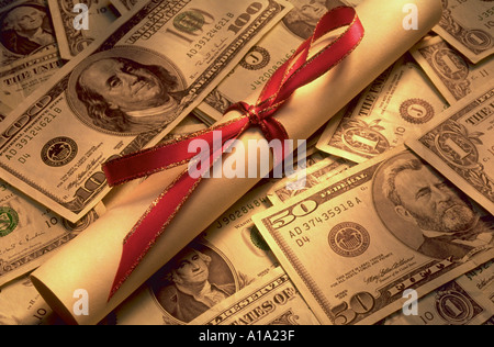 Ancora la vita di un diploma legate con un nastro rosso seduti sulla sommità del denaro Foto Stock
