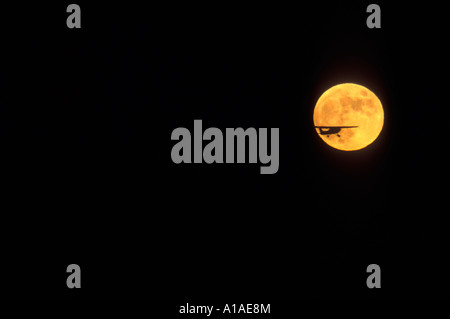 Stati Uniti d'America Alaska piccolo aeroplano si stagliano contro la luna piena sorgere sopra Chugach Mountains vicino a Anchorage Foto Stock