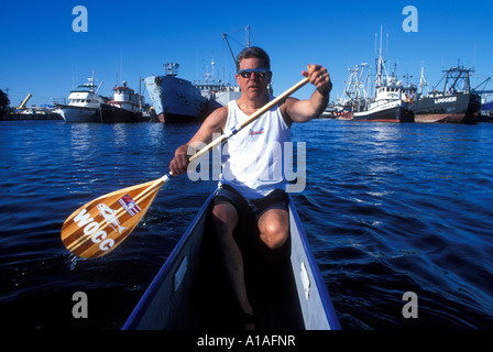 Stati Uniti Washington Seattle Steve Beaudry pagaie canoa outrigger dalle barche da pesca a Fishermans Fall Festival in Ballard Foto Stock