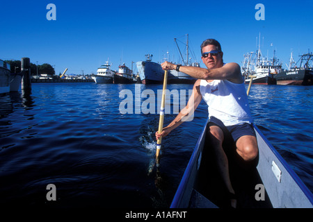 Stati Uniti Washington Seattle Steve Beaudry pagaie canoa outrigger dalle barche da pesca a Fishermans Fall Festival in Ballard Foto Stock