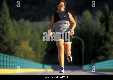 Canada Columbia Britannica Nelson MR Runner e casalinga Joanna Carter fa avanzare sulla strada sul retro in autunno nel sole pomeridiano Foto Stock