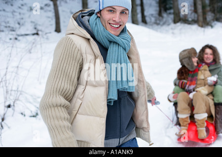 L'uomo tirando le donne su una slitta Foto Stock