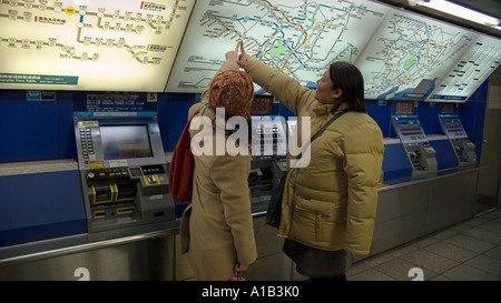 La stazione di Ginza di Tokyo metropolitana centrale di Tokyo Giappone due donne che indica simultaneamente la loro destinazione prevista Foto Stock