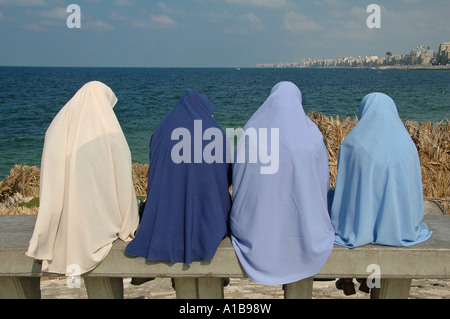 Le donne egiziane indossando il tradizionale velo Khimar seduto alla passeggiata lungomare Corniche nella città di Alessandria d'Egitto Foto Stock