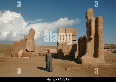 Un uomo egiziano si trova presso la porta monumentale di Shoshenq III Al sito antico tempio di Tanis nel Nilo orientale fiume delta Alto Egitto Foto Stock