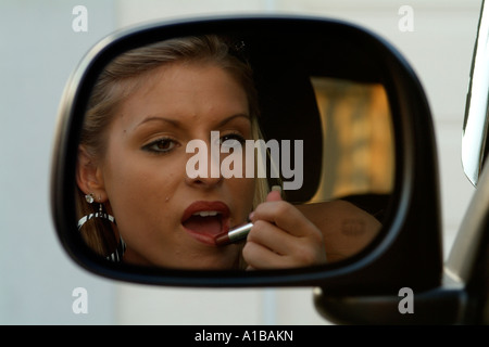 Driver donna rossetto utilizzando una macchina specchietto laterale Miss Pensacola USA Chelsea Cooper Foto Stock