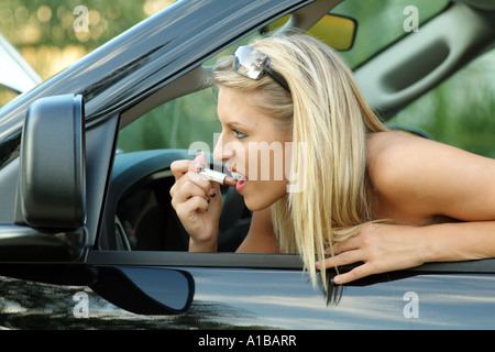 Chelsea Cooper Miss Pensacola USA auto conducente rossetto usando uno specchio Foto Stock