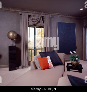Cuscini colorati su grigio chaise-longue, vista attraverso la finestra Foto Stock