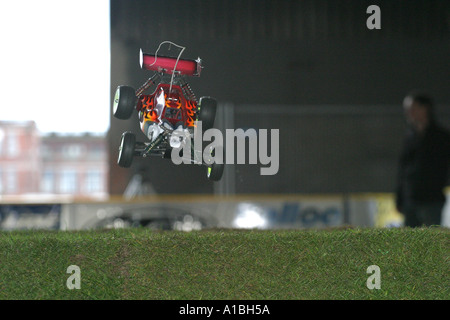 Off road buggy radio comando auto buggy racing in aria al di sopra di un salto di erba indoor via Belfast Irlanda del Nord Foto Stock