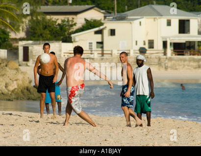 Barbados calcio sulla spiaggia a farfalla Maxwell Cristo chiesa parrocchiale tra i giovani visitatori e Bajan locali Foto Stock