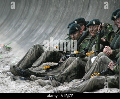 Royal Irish Regiment RIR soldati rilassarsi sotto il mare difese a Portrush West trefolo dopo la loro mock beach assault durante l'esercizio militare Foto Stock