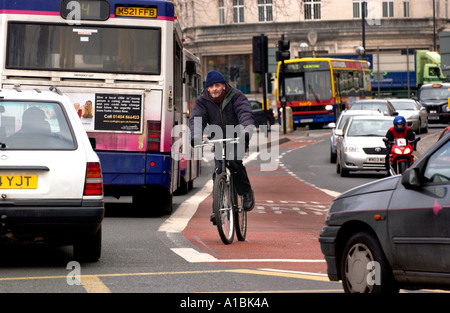 Ciclista utilizzando corsia degli autobus nel centro città di Bristol England Regno Unito Foto Stock