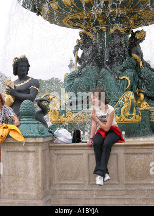 Ragazza seduta sul bordo fontana sulla Place de la Concorde Parigi Francia Foto Stock