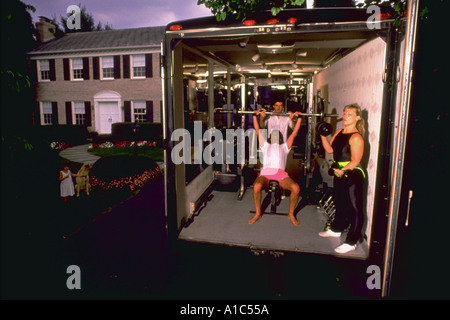 Il marito e la moglie e il trainer workout nella flotta Fitness palestra mobile nella zona suburbana di viale di accesso Foto Stock