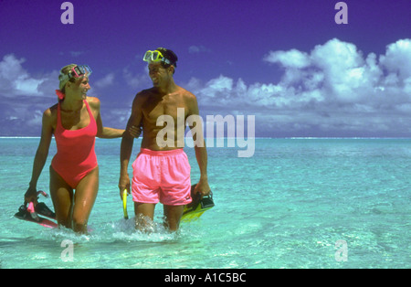 Giovane indossando maschere per lo snorkeling e le pinne a piedi in acqua poco profonda in laguna a Matira Beach Bora Bora Polinesia Francese Foto Stock