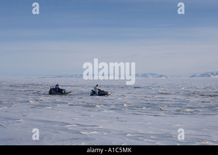 Viaggiando in macchina da neve e sled sulla congelati Oceano Artico off isola Herschel Yukon Territory Canada Foto Stock