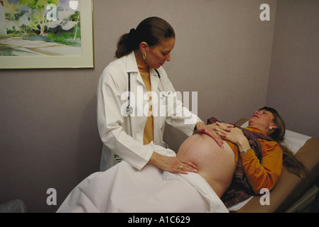 Ostetrico femmina esaminando 8 mese 5 pazienti in stato di gravidanza Foto Stock