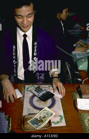 Imprenditore giapponese ristoratore dando cambiare in yen dopo una transazione prese a Tokyo il business viaggi persone Foto Stock