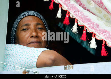 La donna in una casa tradizionale su palafitte con persiane al Villaggio Malese Pulau Pangkor island Malaysia Foto Stock