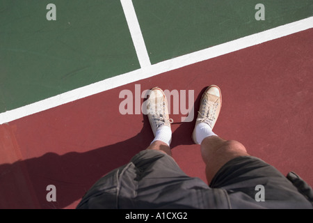 Uomo in piedi su un campo da tennis Foto Stock