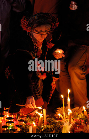 La donna in una corona di spine accendere una candela Foto Stock