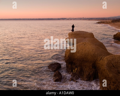 La pesca con lenza in mare nel tramonto a spiaggia di Galé circa 7 km ad ovest di Albufeira Algarve Portogallo Foto Stock