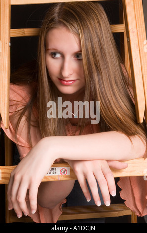 Caucasian Teen Girl (14-16) appoggiata contro la scaletta Foto Stock