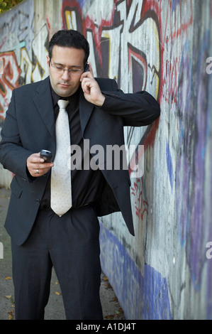 Imprenditore è chiamata di fronte a un muro di graffiti Foto Stock