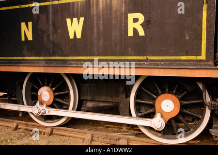 Primo piano delle ruote motrici e delle aste laterali della locomotiva a vapore NWR ST 707, con vernice nera e scritta gialla NWR. Foto Stock