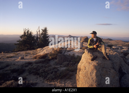 Un escursionista seduto sulla cima di un masso su un picco di montagna nel granito Chief deserto, Tahoe National Forest,California Foto Stock