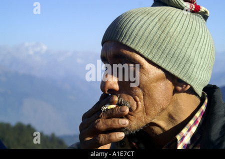 Ritratto volto di molto vecchio uomo indiano highlander fumare a prato alpino in Himalaya indiano, India Foto Stock