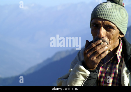 Ritratto volto di molto vecchio uomo indiano highlander fumare a prato alpino in Himalaya indiano, India Foto Stock