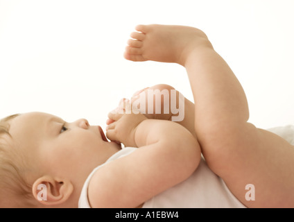 Baby mettendo piede in bocca Foto Stock