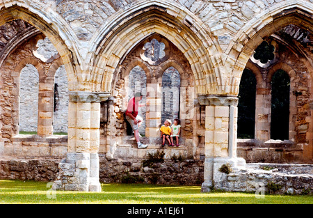 Papà e bambini piccoli di visitare le rovine della vecchia abbazia nel Hampshire REGNO UNITO Foto Stock