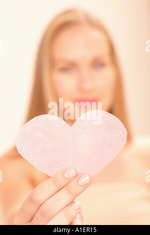 Donna che mantiene cuore rosa Foto Stock