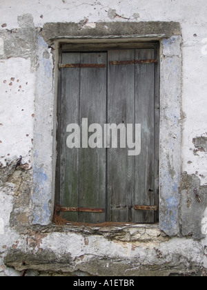 Finestra con Vecchie persiane di legno e cerniere arrugginito Foto Stock