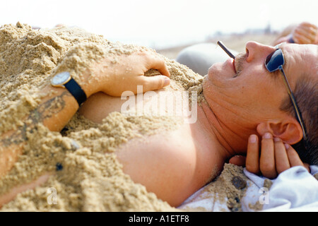 L'uomo coperto di sabbia Foto Stock