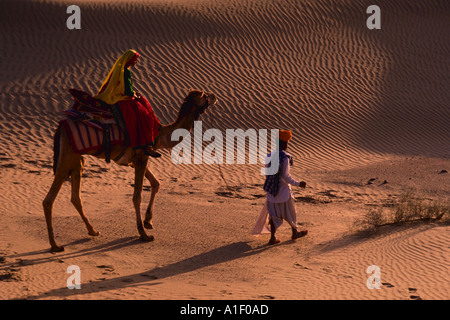 Indiana leader uomo donna indiana a cavallo sul dorso di un cammello nel deserto Jaisalmer Rajasthan in India Foto Stock