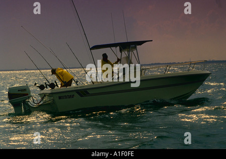 Due uomini trolling saltwater in barca fuoribordo Foto Stock